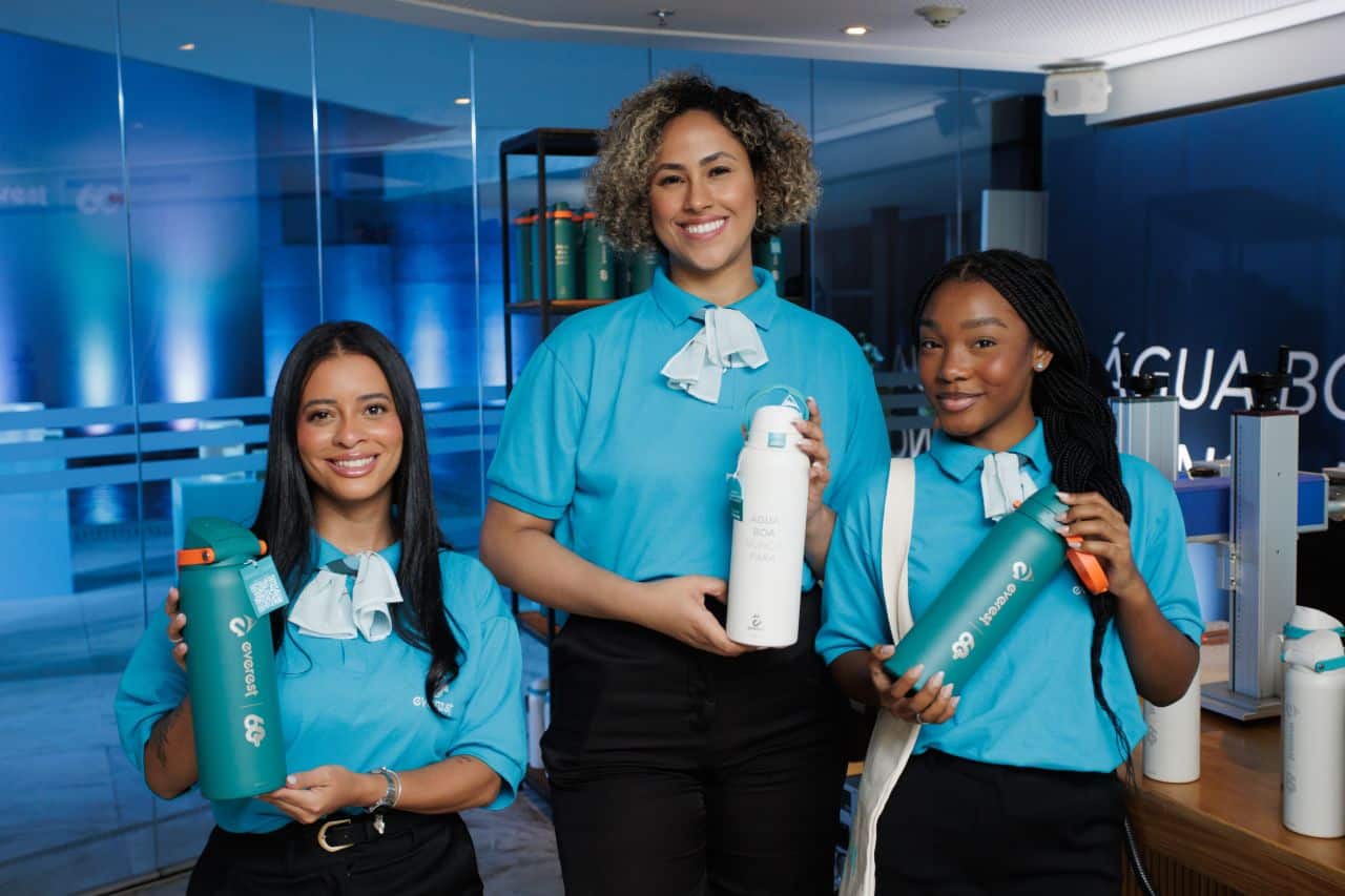 Promotoras uniformizadas com garrafas Everest durante o coquetel