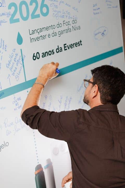 Convidado escreve no mural da linha do tempo dos 60 anos da Everest
